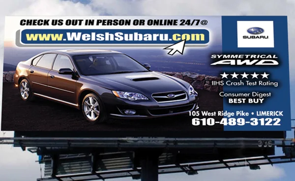 Welsh Subaru billboard showing a dark Subaru sedan and the dealership web address